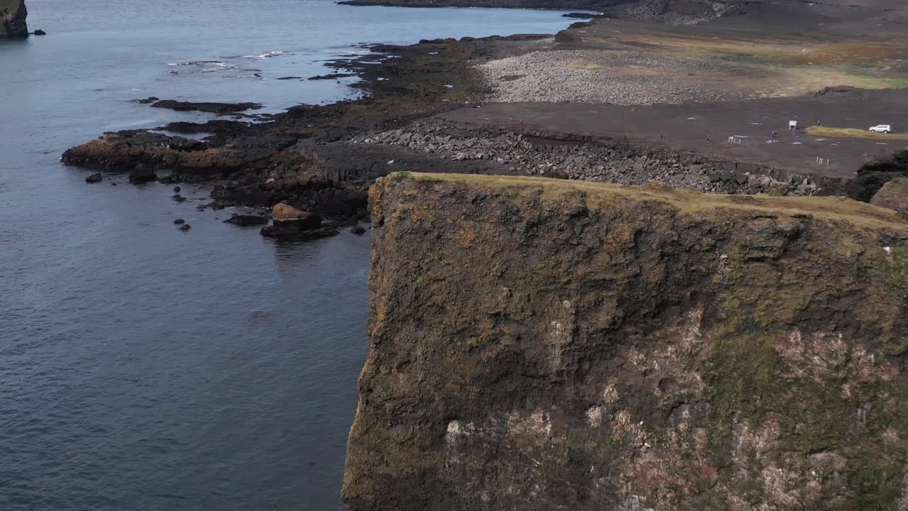 volando más allá de los acantilados que revelan grandes rocas en la playa en islandia