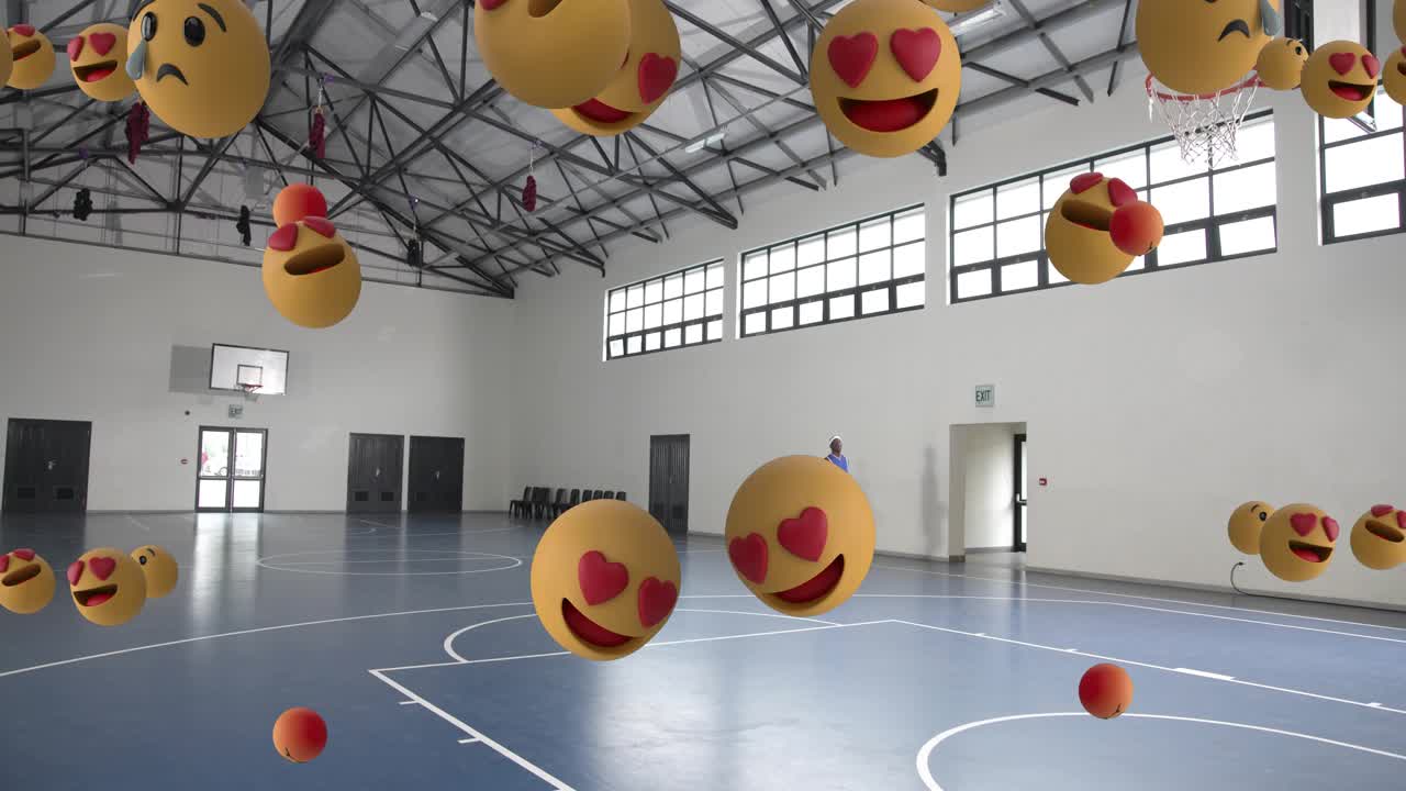 Pemain bola basket pria berjalan di lapangan olahraga setelah penundaan, bola emoji naik dan menghalanginya