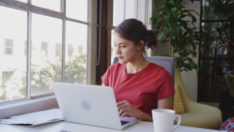 Millennial-hispanische-Kreative-Frau,-Die-An-Einem-Schreibtisch-Mit-Laptop-In-Einem-Büro-Sitzt,-Lockdown