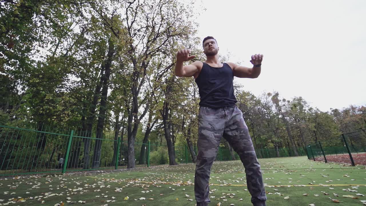 Healthy athlete doing his workout outdoors. Sportive man is exercising on the stadium near the autumn park. Slow motion.