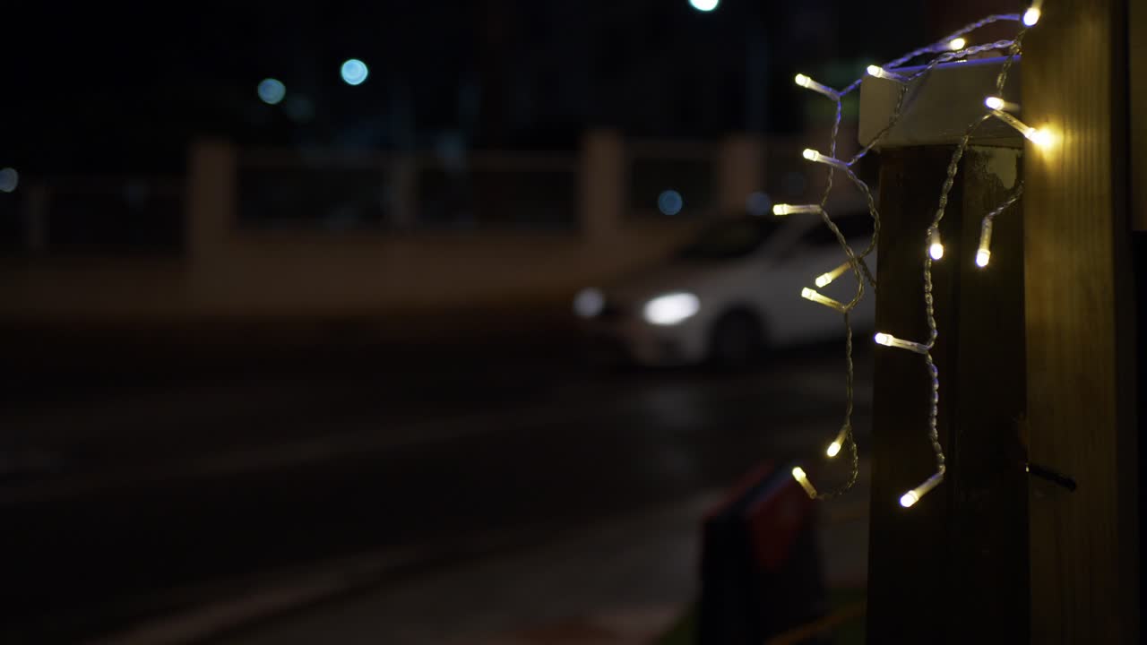 luces decoración en una calle. noche oscura. coches que pasan.