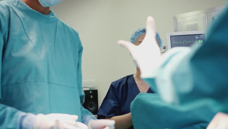 surgical team working on patient in hospital operating theatre