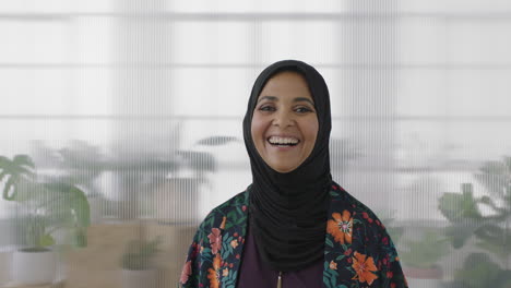 portrait of senior muslim business woman laughing cheerful looking at camera wearing traditional headscarf mature experienced female in office workspace