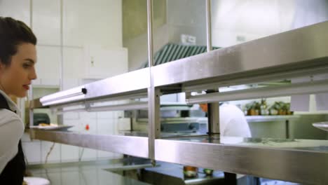 chef handing food dish to waitress at order station 4k