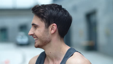 Close-up-smiling-man-looking-camera-outdoor.-Cheerful-guy-on-city-street