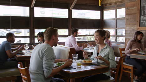 una pareja joven hablando durante el almuerzo en un restaurante, r3d