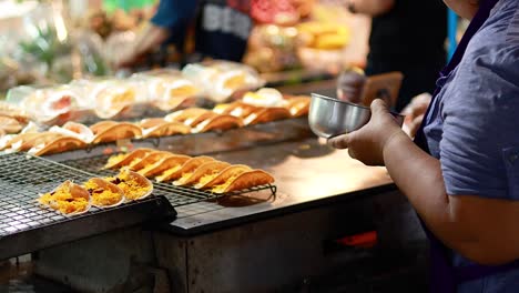 vendor prepares pancakes at floating market stall