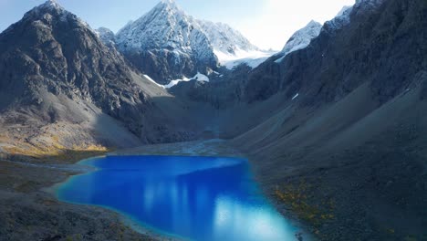 a bright blue glacier lake bleisvatnet in a mountainous lynge alpen valley with snowy peaks