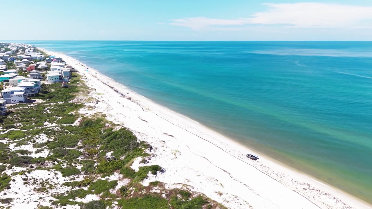 Volo panoramico con drone sopra la spiaggia di sabbia bianca di Cape San Blas, con acque color smeraldo del Golfo e dune, durante una giornata di sole, Florida, USA