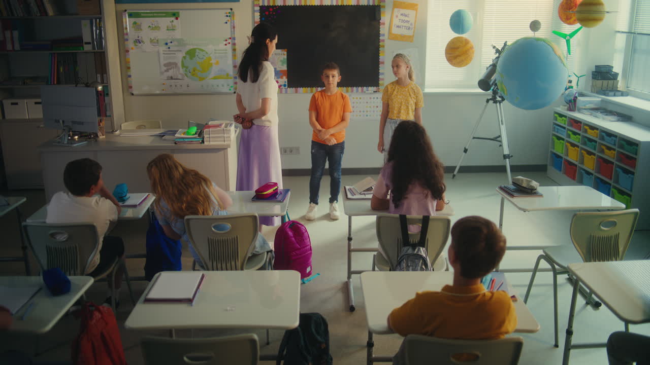 Primary School Boy and Girl Presenting Homework on Renewable Energy in Front of Class