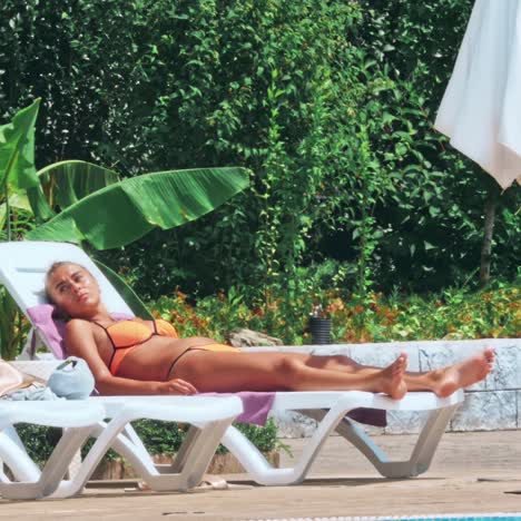 sensual young woman relaxing near swimming pool.