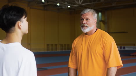 Senior-and-young-man-talking-indoors