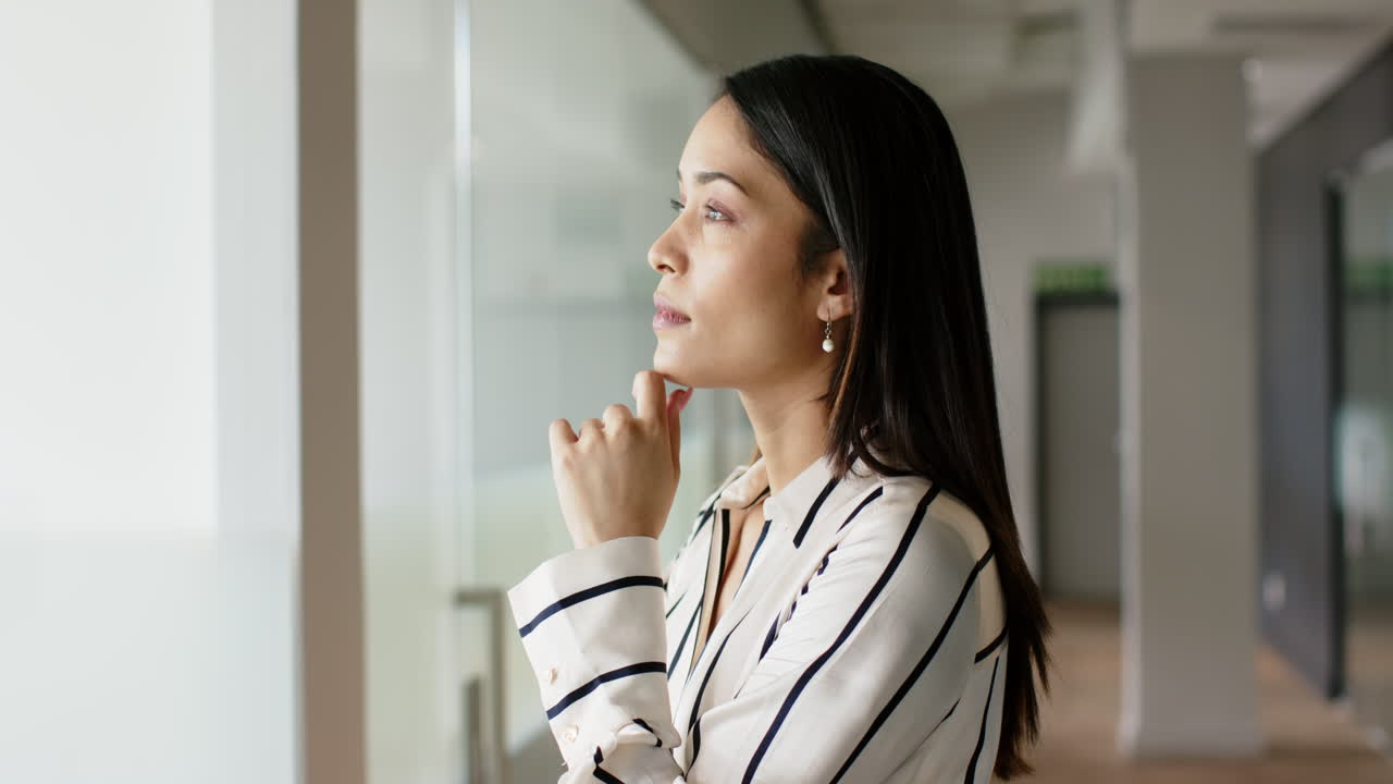 Standing confidently in office hallway, businesswoman looking at camera