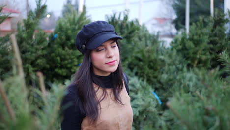 a hispanic woman in the holiday spirit shopping for festive christmas trees