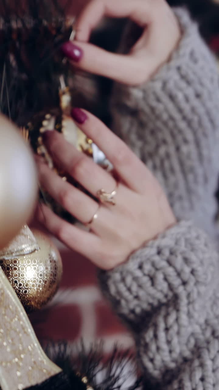 Woman decorates Christmas tree. Woman decorating the Christmas Tree at home during the Christmas period Vertical video