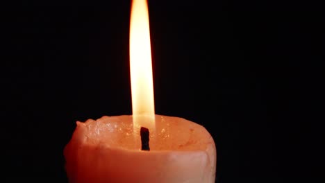 las vitrinas de coloridas velas individuales sobre fondo negro con el efecto de la luz y la cámara lenta