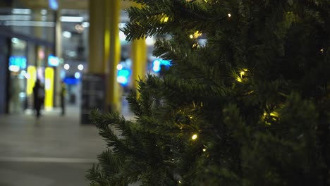 Close-up-Christmas-tree-with-defocused-festive-shoppers-in-background