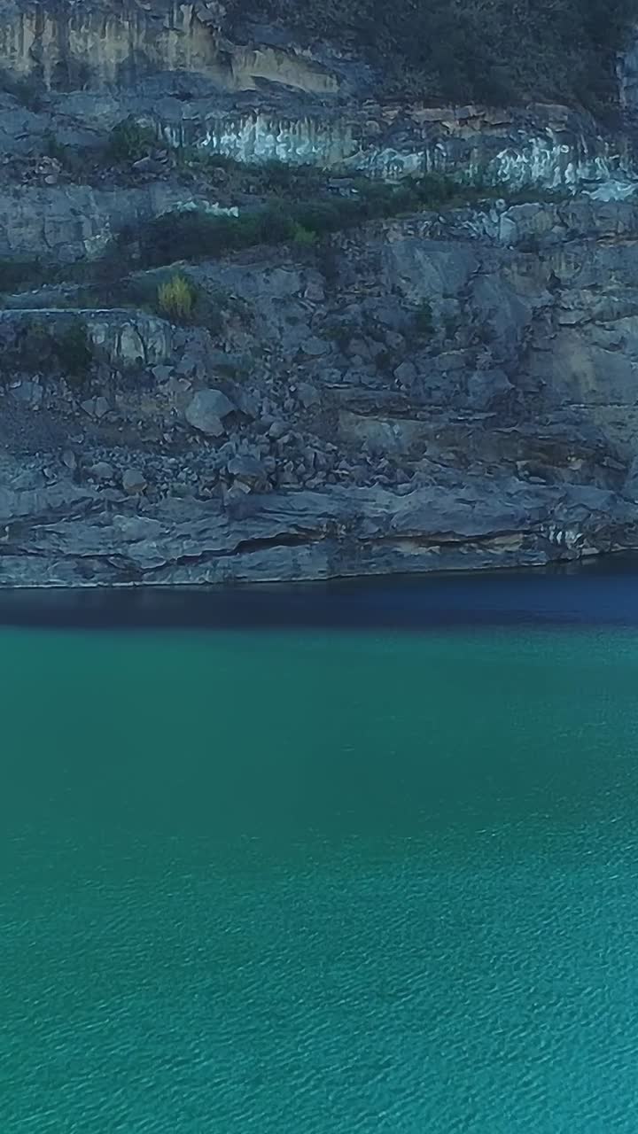 Vista del Lago Colbun in Cile con paesaggio roccioso e una diga.