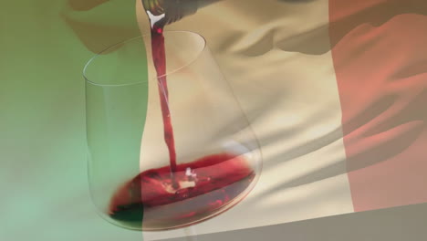 composite of red wine being poured into glass over flag of italy background