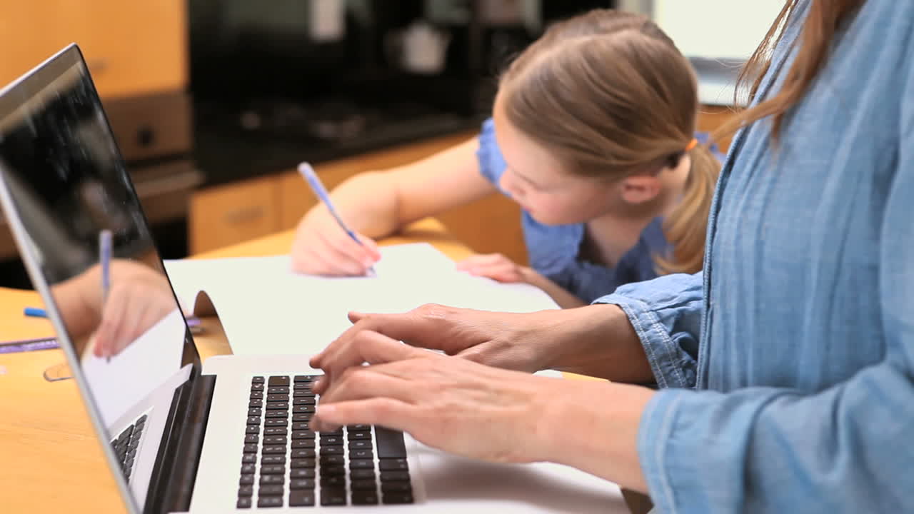 una niña dibujando junto a su madre