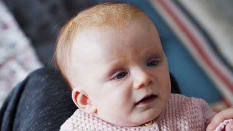 sweet baby girl grabbing parents arms and fingers