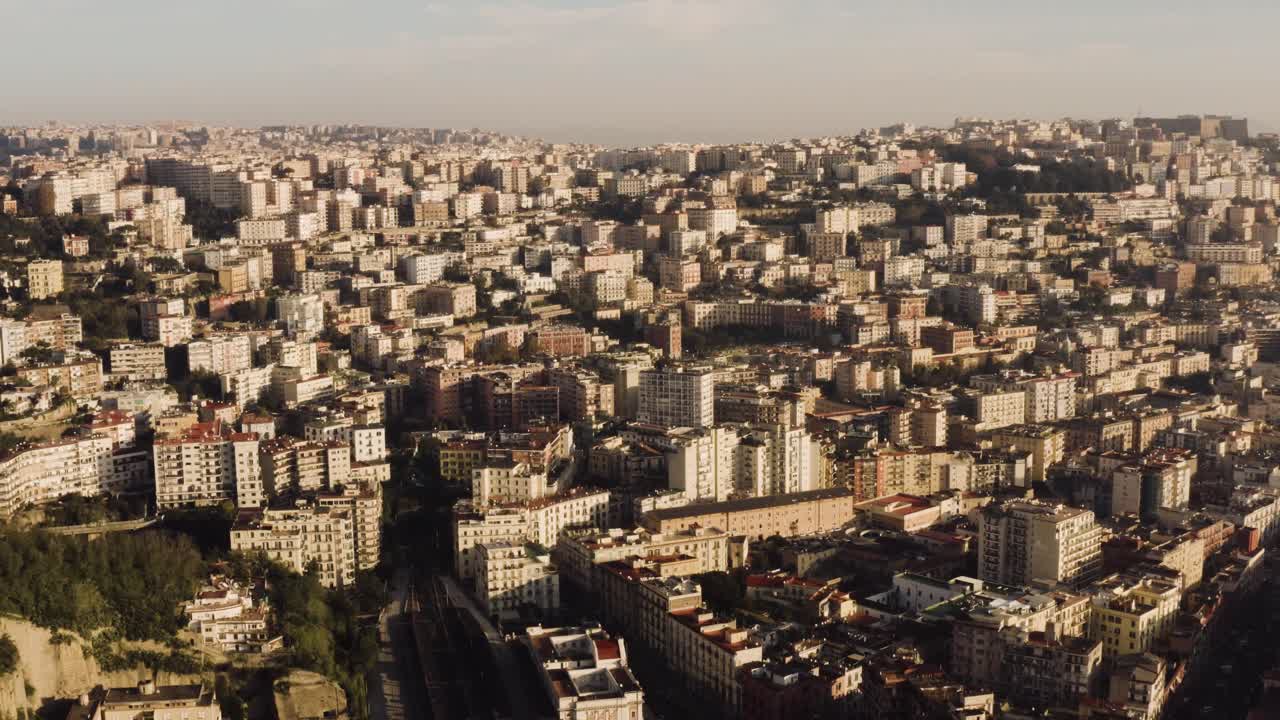 toma aérea hacia adelante que muestra la hermosa ciudad histórica de nápoles ubicada en una colina durante la puesta de sol por la noche - toma de avión no tripulado