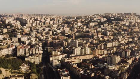 Aerial-forward-shot-of-showing-beautiful-historic-city-of-Naples-located-on-hill-during-sunset-in-the-evening---Establishing-drone-shot