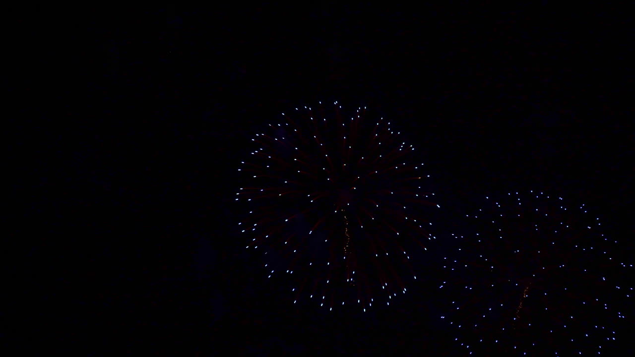 The night sky fills with rings of red, white and blue fireworks