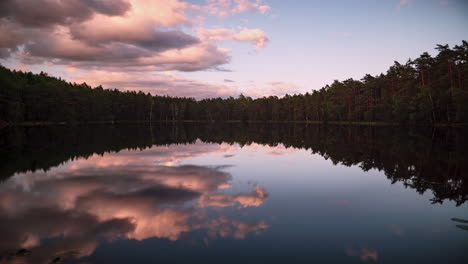 Timelapse-of-majestic-hues-over-Paunküla-reservoir-at-dusk,-waterbody-reflection-of-bursting-clouds-in-Estonia