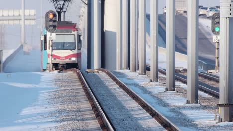 calgary light rail transit train on icy cold tracks, sunny afternoon