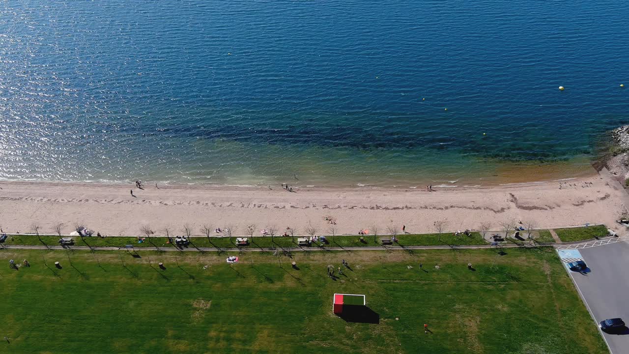 일광욕과 목욕을 즐기는 사람들이 있는 호수 해변, 정원과 산책로