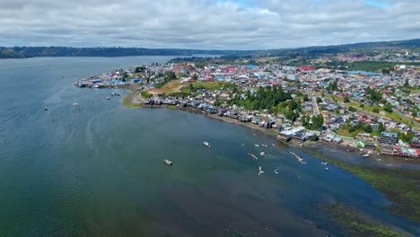 aerial panoramic landscape of chiloé island patagonia chile travel sea destination blue holiday village on top of green summer hills, establishing drone