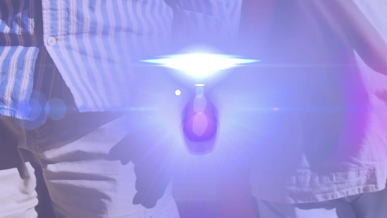 손을 잡고 공원에서  ⁇ 고 있는 노인 부부의 중간 부분을 가로질러 움직이는 빛의 애니메이션