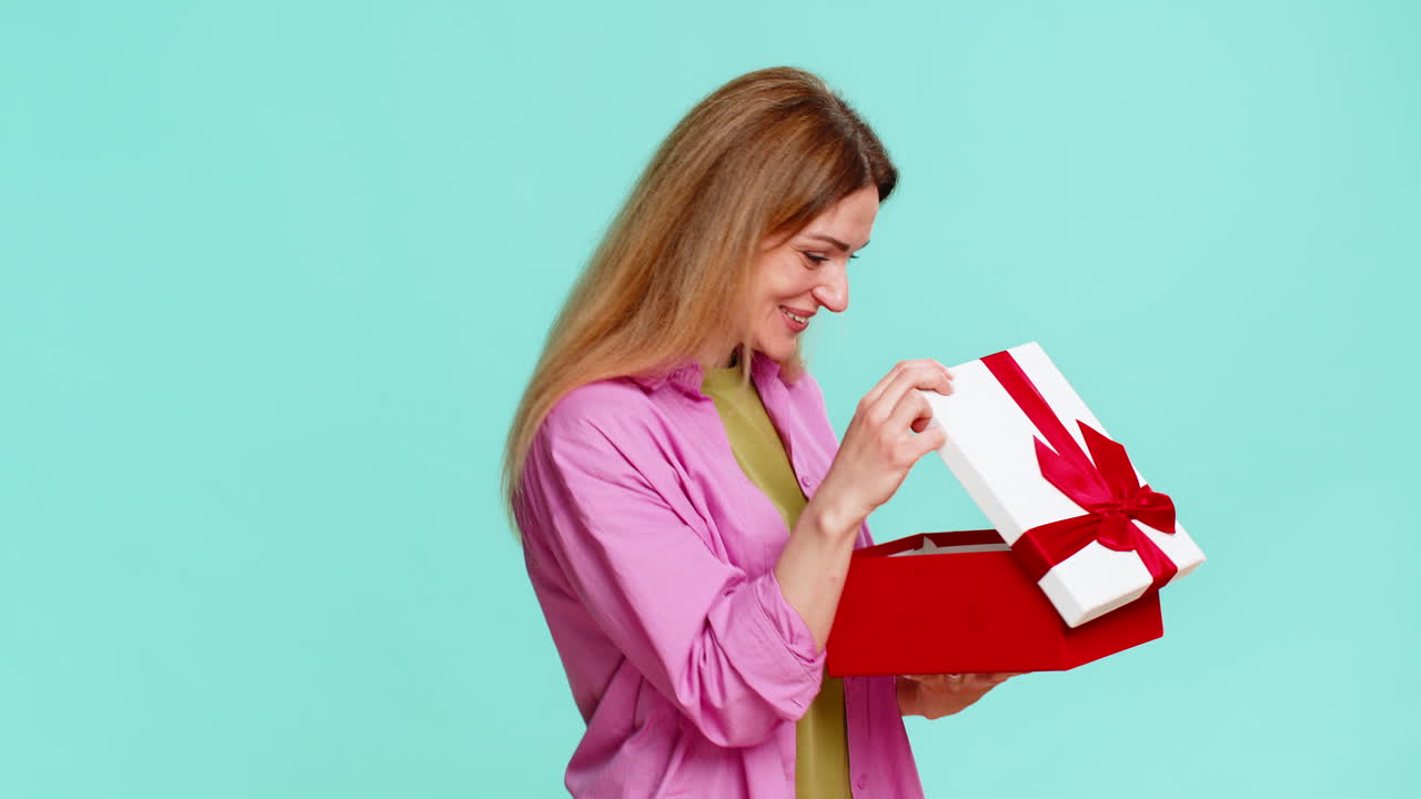 Woman opening gift box with excitement showing joy surprise celebration moment with cheerful smile