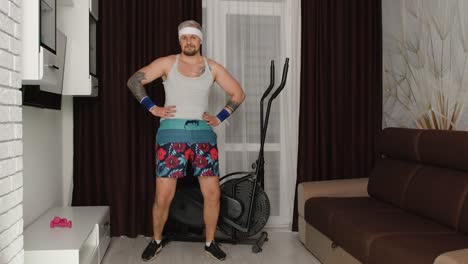Funny-man-athlete-sportsman-with-beard-makes-workout-stretching-exercises,-practicing-sport-at-home
