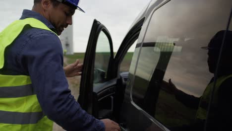 un profesional latino vino al campo con un molino de viento con una caja de herramientas.