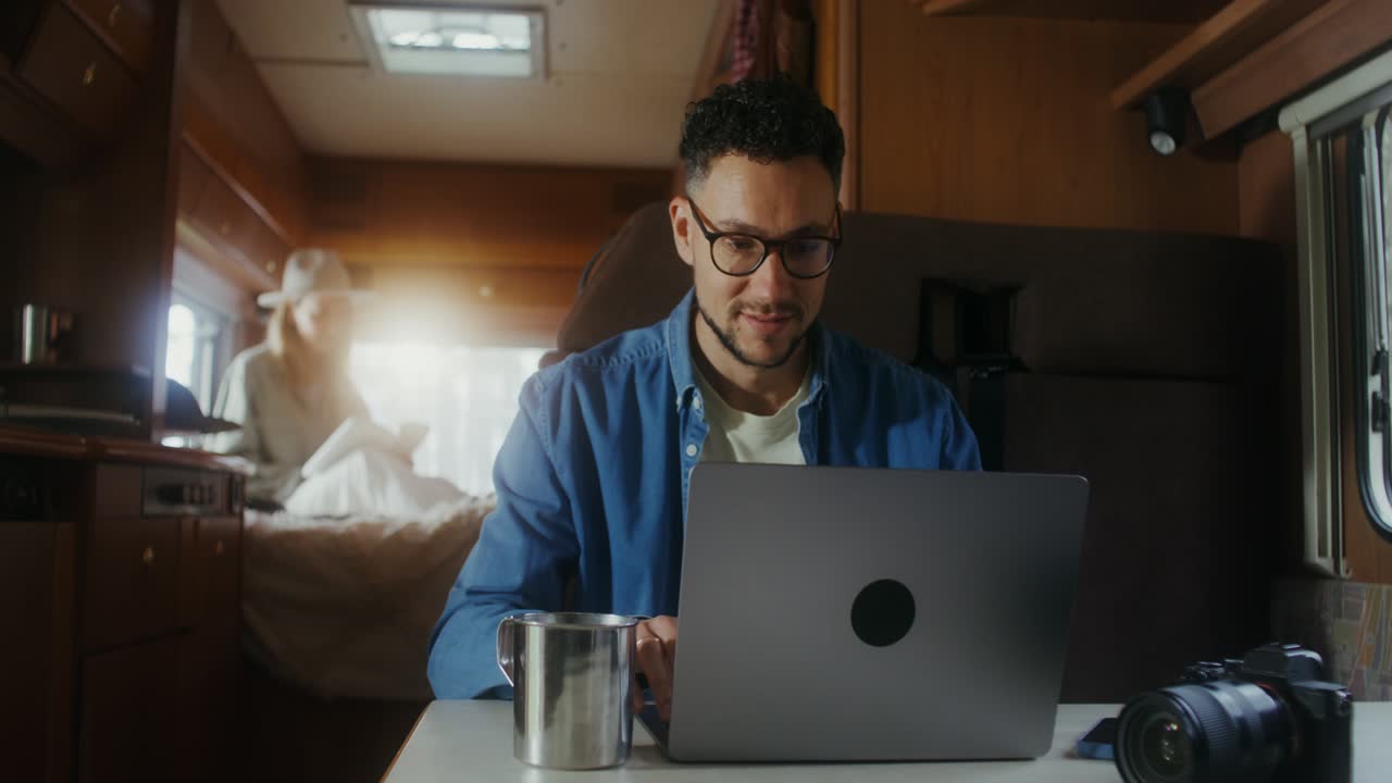 hombre trabajando en una computadora portátil en una caravana