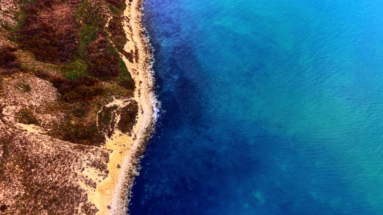 Contrasto tra il bordo erboso della scogliera e l'oceano blu. Ripresa aerea della costa e del mare