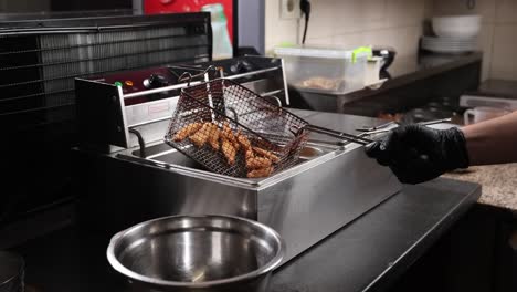 chef cocinando pollo frito en la cocina de un restaurante