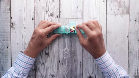 person using a weekly pill organizer