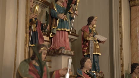 ornate religious statues of saints holding symbols in a richly decorated church interior