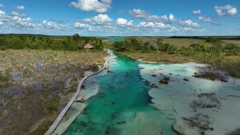 aerial view over tourists enjoying in the rapidos de bacalar, in sunny mexico