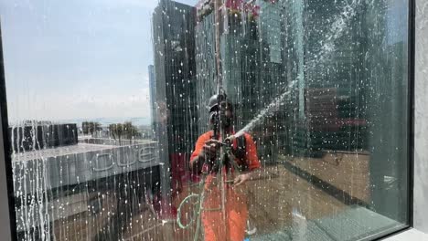 window cleaner hanging on a rope abseiling on a high rise office building in singapore