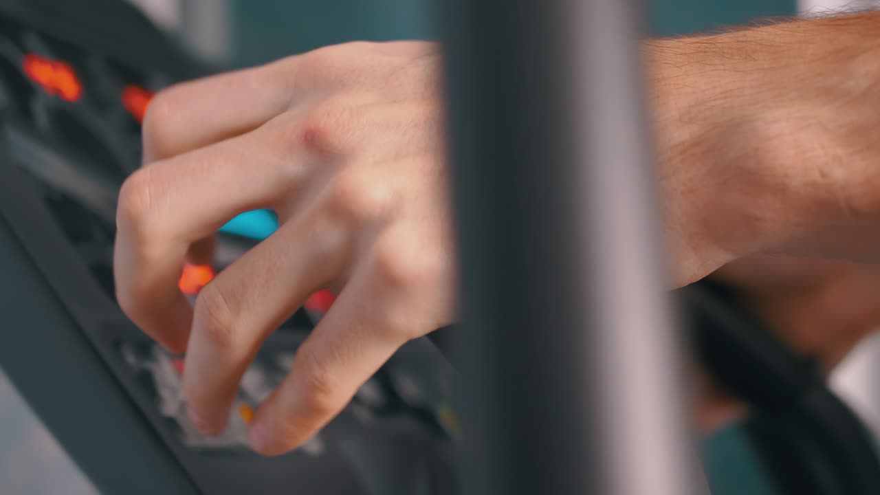 el atleta entrena en un entrenador elíptico en casa, observando el ritmo cardíaco en el monitor