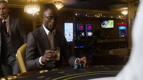 multiethnic group of people joining the poker table in the casino.