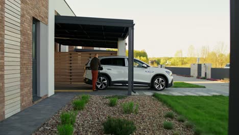 hombre cargando un suv eléctrico en casa