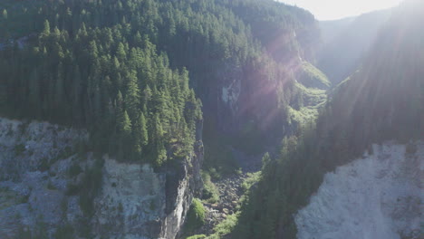 aerial view of ravine in rugged pacific northwest mountains with sun flare