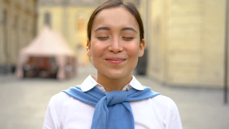 Portrait-of-cheerful-asian-woman-taking-off-her-medical-mask-and-taking-a-deep-breath-outdoors-after-coronavirus-lockdown.-COVID-19-pandemic.