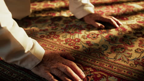 man prays for ramadan on carpet during sunny day