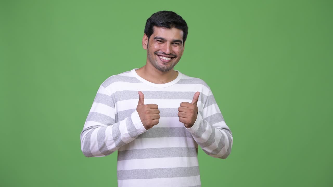Young handsome Persian man giving thumbs up